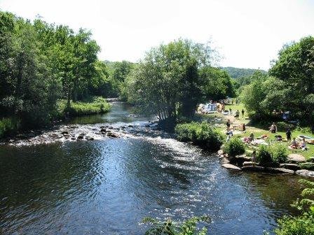 Families picnicking on the beautiful river bank of Spitchwick Common