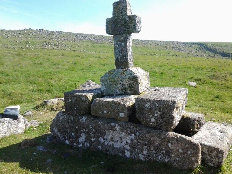 Large granite cross on top of a remote granite tomb