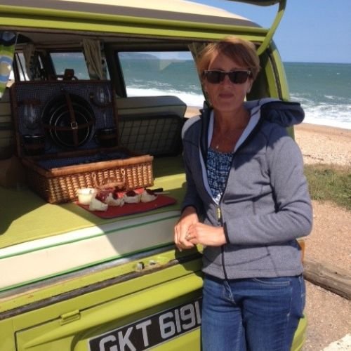 Guests enjoying a Devon Cream Tea by the beach served from the back of their vintage VW camper