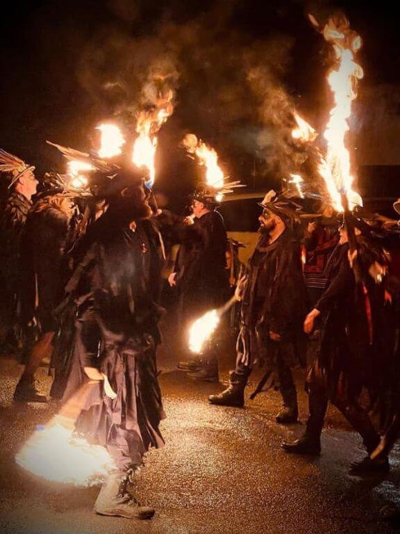 Morris-dancers-in-black-with-burning-torches