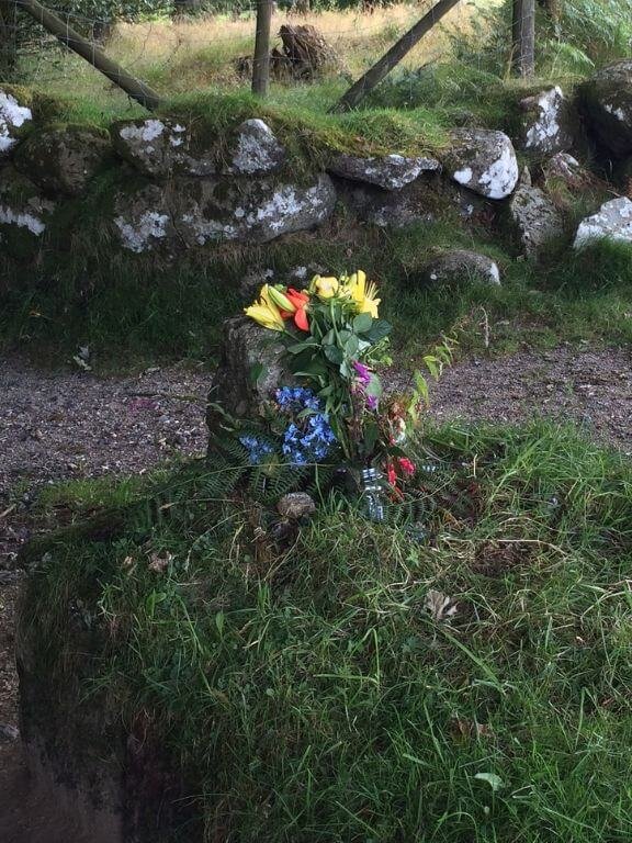 Close up of mysterious flowers laid on Kitty Jay's roadside grave