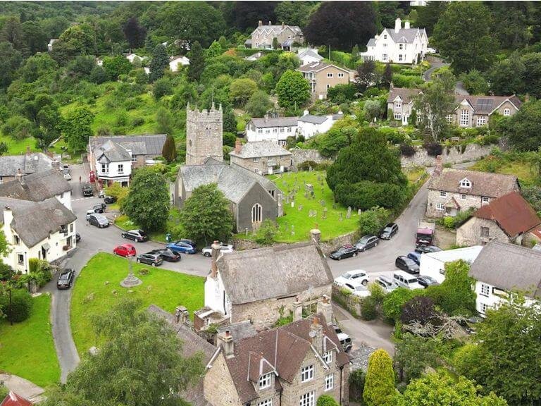 Aerial view of Lustleigh showing thatched dartmoor cottages nestled around the village church and pub