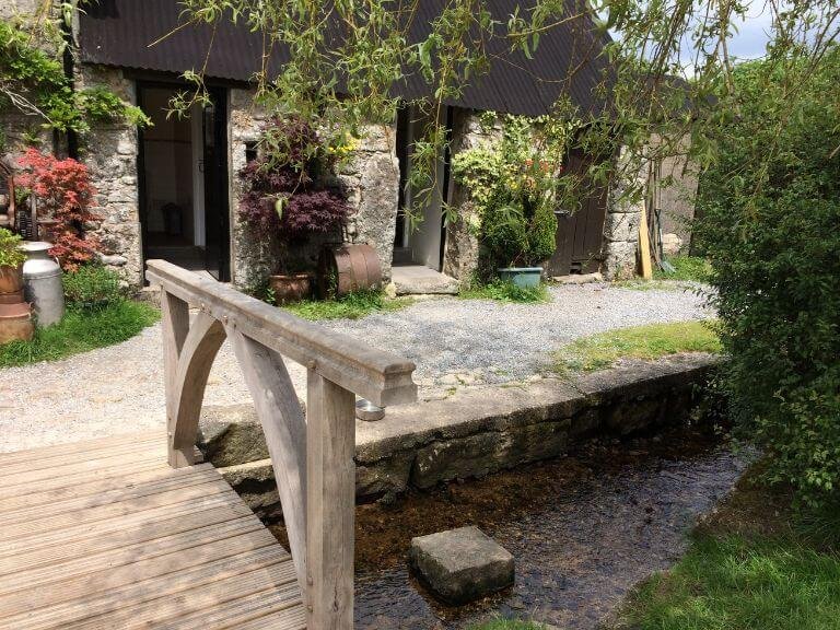 Quaint wooden bridge across running brook in pub garden