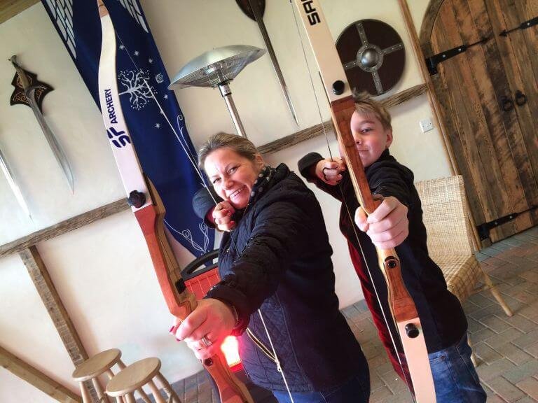 Mother and son taking aim with archery bows in Lord of the Rings themed range